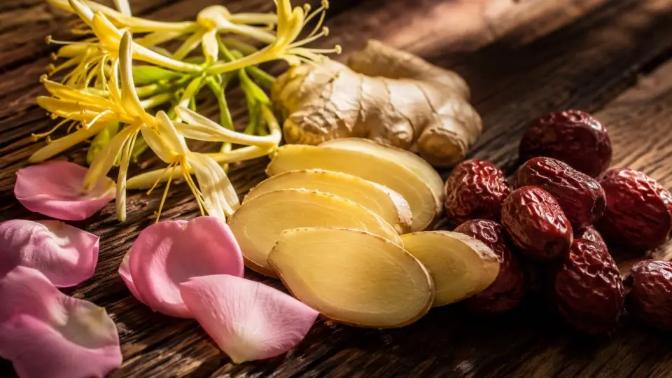 A Rustic Wooden Platter with Fresh Ginger Slices, Honeysuckle Flowers, and Rose Petals A Rustic Wooden Platter with Fresh Ginger Slices, Honeysuckle Flowers, and Rose Petals